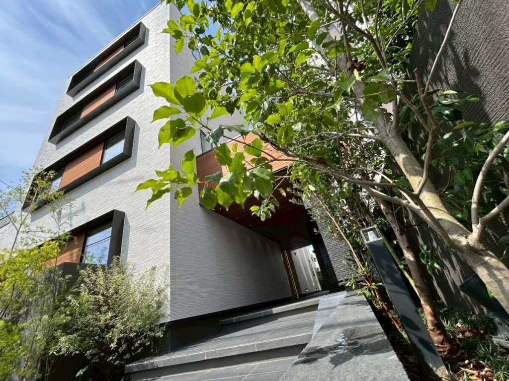 建物と調和したエントランスのタイルステップと植栽