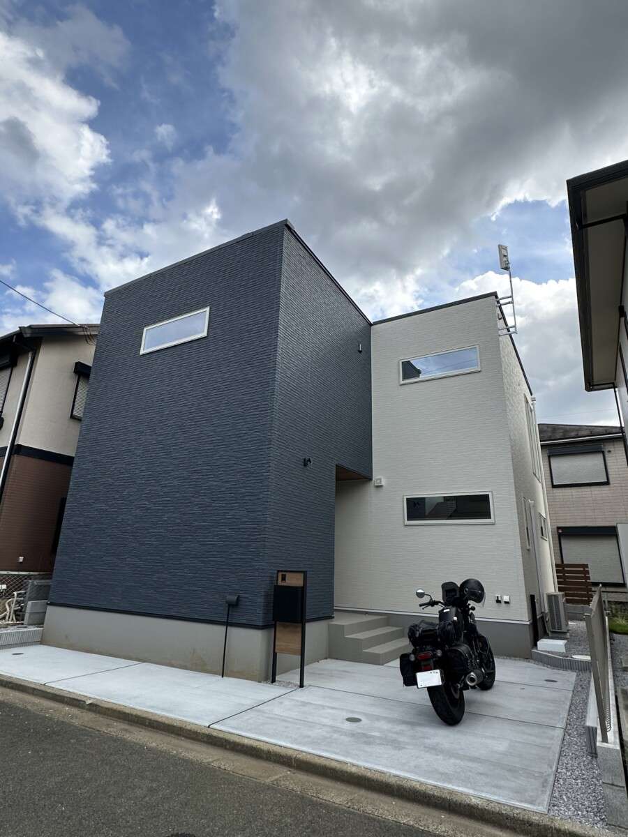 伸縮目地で整えた土間コンクリートのアプローチとグレー砕石の駐車スペース