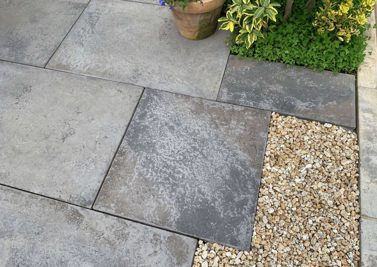 自然石調のアプローチと異素材の組み合わせが美しい外構デザイン。砕石と下草が空間にメリハリを加える。