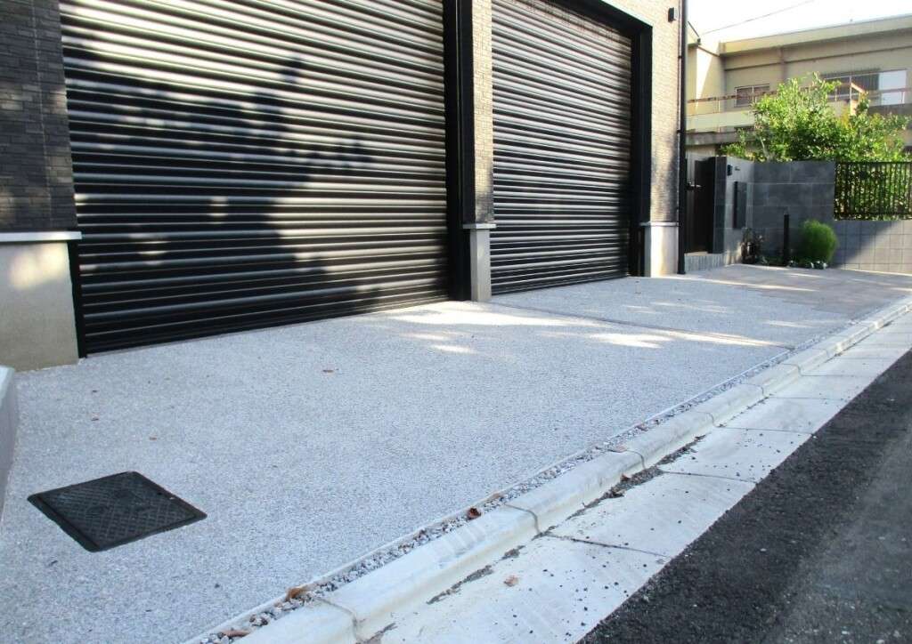グレー調の大判インターロッキングと洗い出し仕上げで仕上げた上品なアプローチ空間