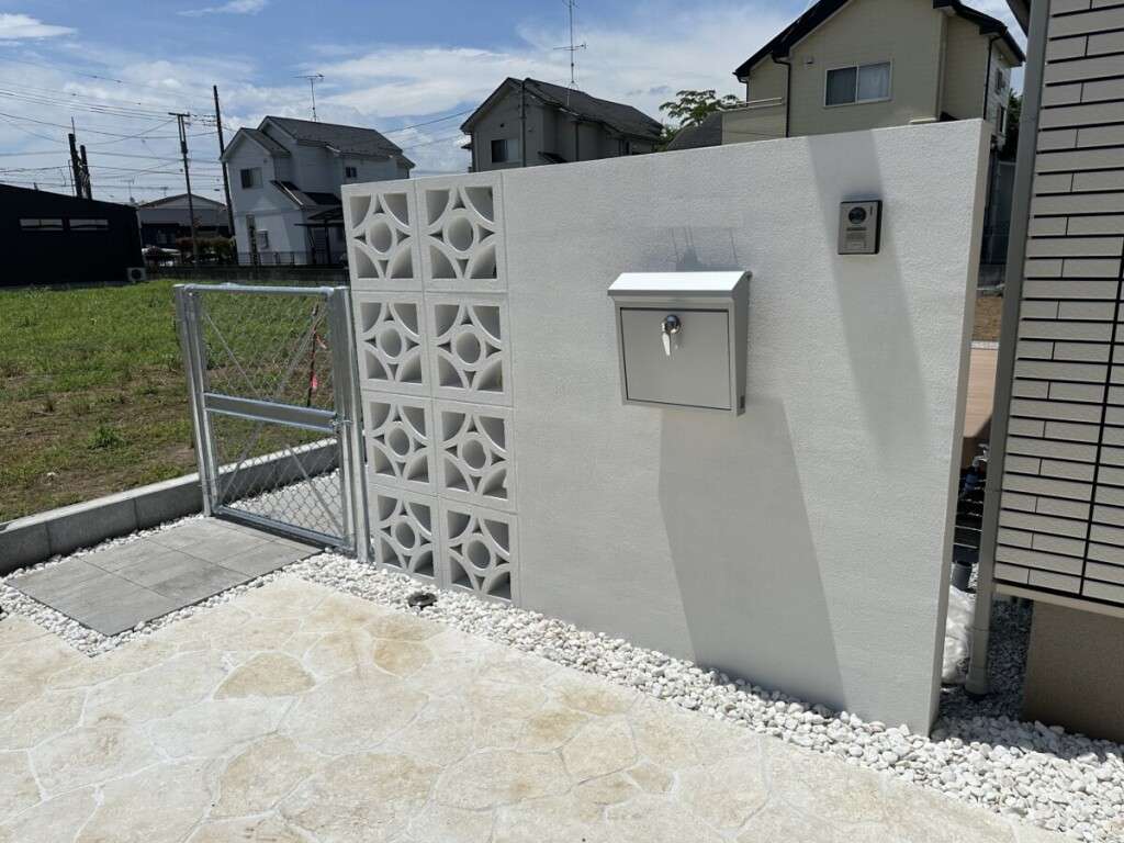 琉球石灰岩を敷き詰めたアプローチと白い門柱の全体風景