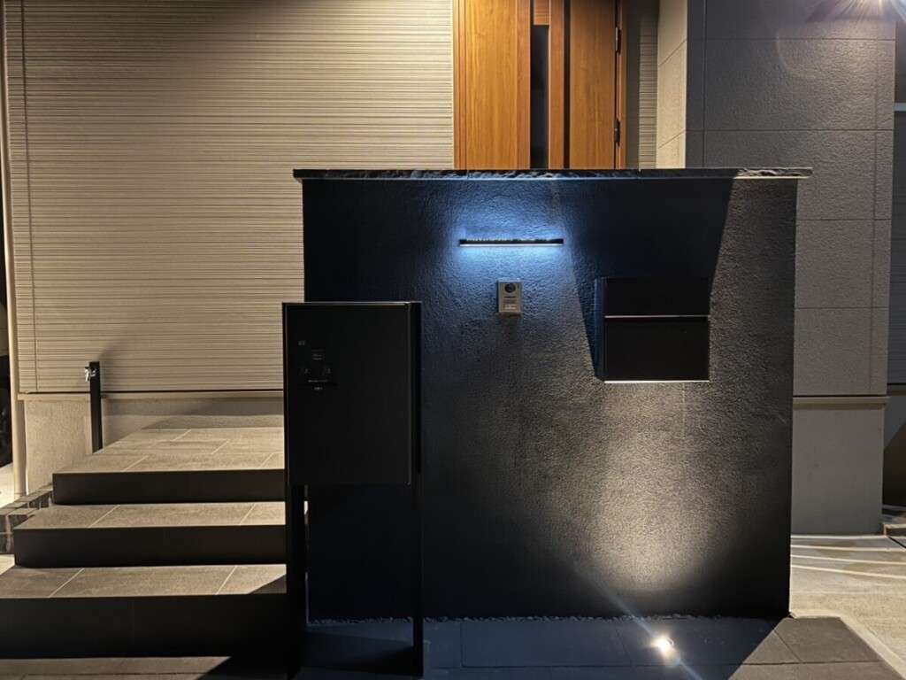 グレーのタイル階段と門柱を備えた新築外構全体の夜の風景