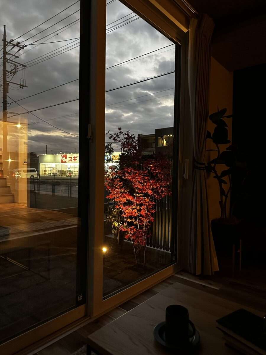 リビングから眺めるYKKルシアススクリーンフェンスと奥のイロハモミジの夕景