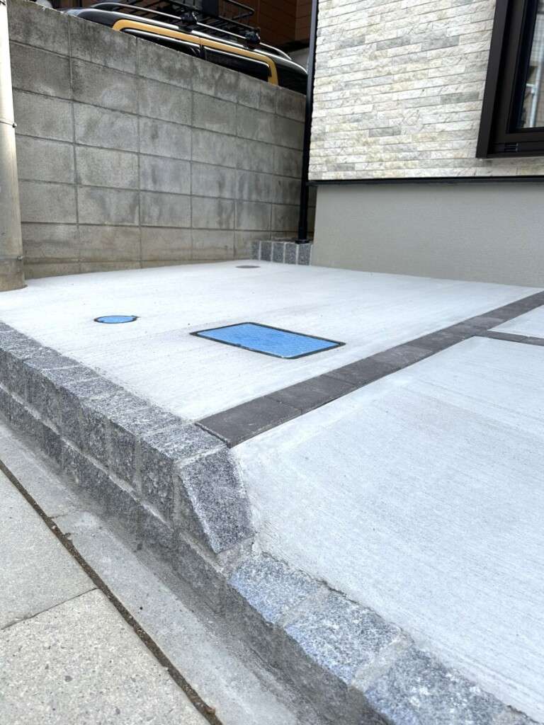 自然石ピンコロで段差を演出した駐車スペース横の境界側アプローチ