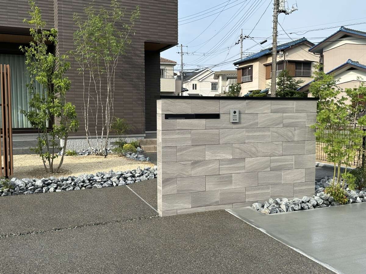 駐車場とアプローチを区切る洗い出し舗装とスロープ