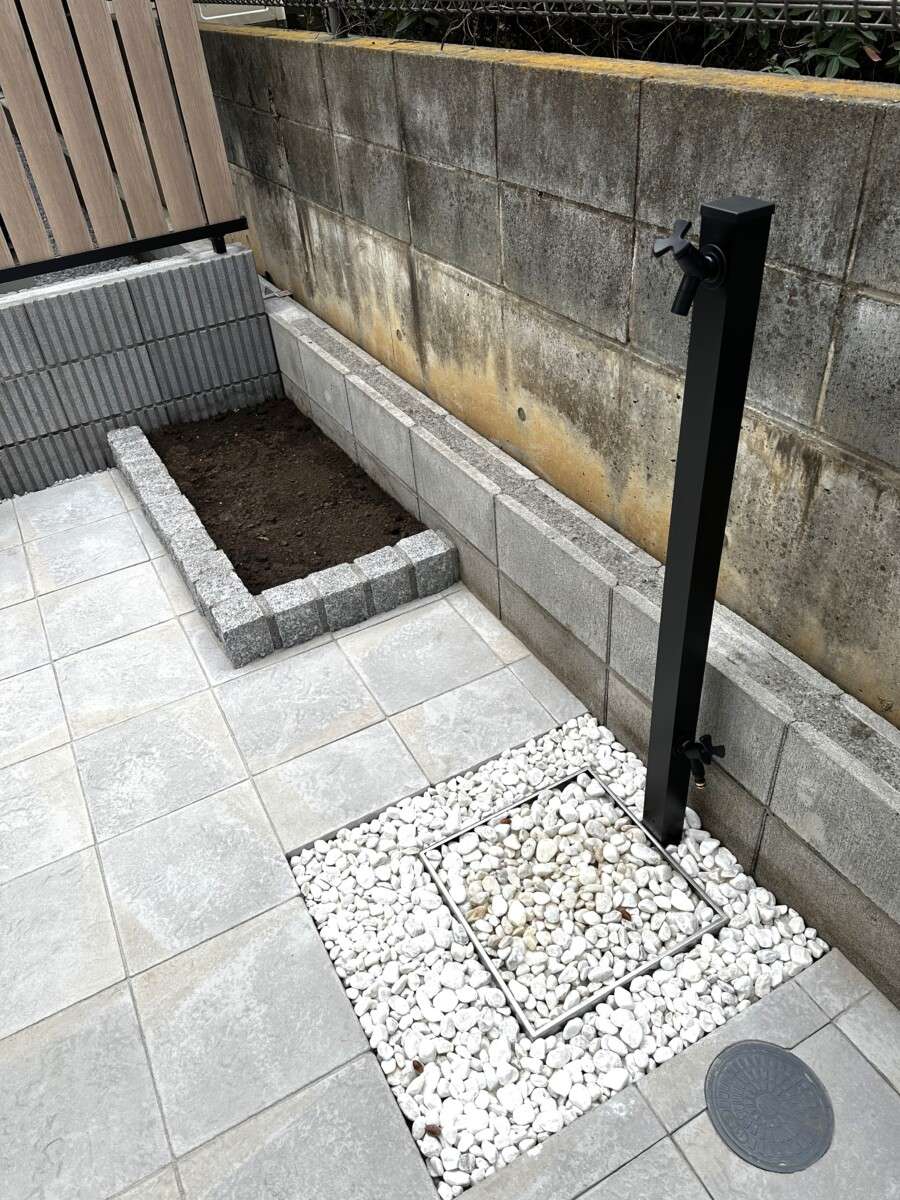 お庭の空間を引き締める、ブラック色のスタイリッシュな立水栓と植栽の緑。