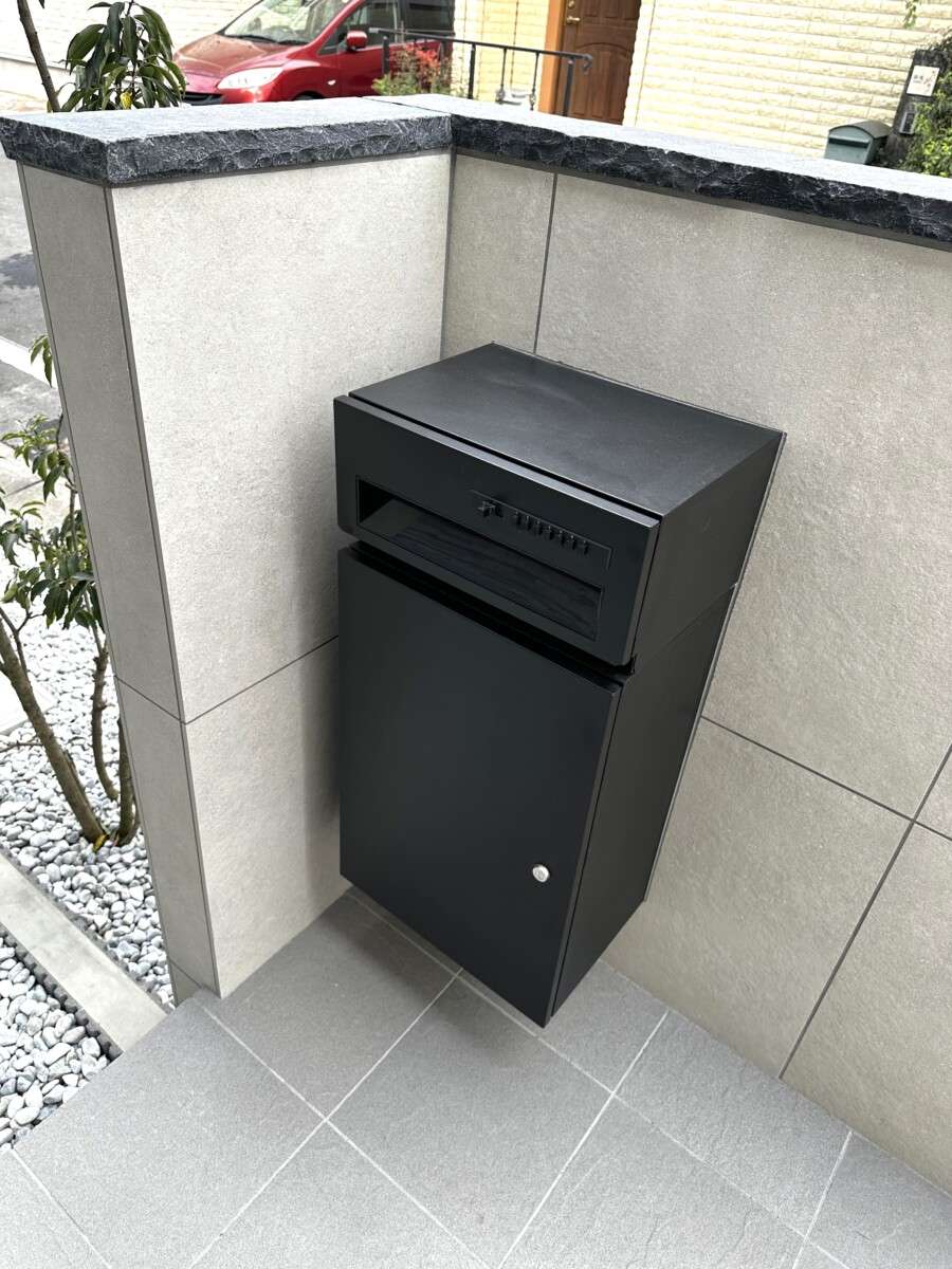 重厚感のある600角タイル貼りの門柱と、ブラックで統一し引き締めた宅配ボックス・ポストまわり。