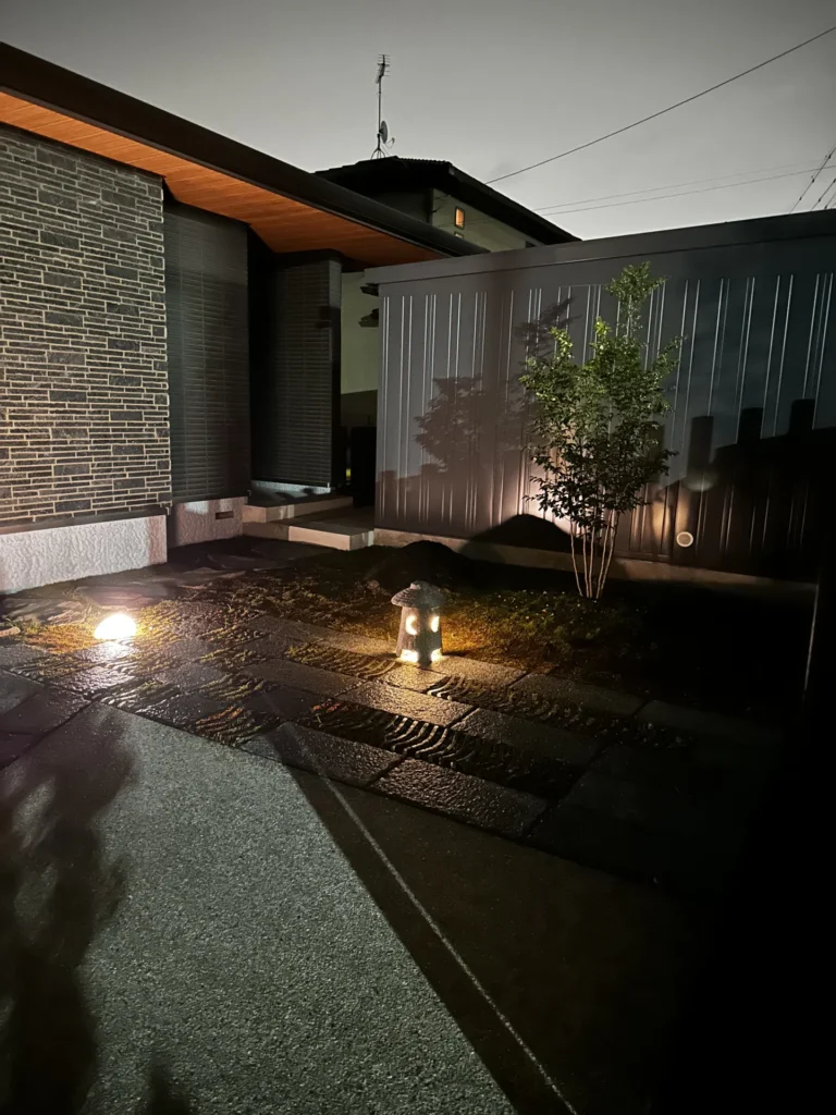 和モダン中庭の夜景。苔と自然石がライティングに照らされ、昼間とは趣の異なる静かな表情を見せる