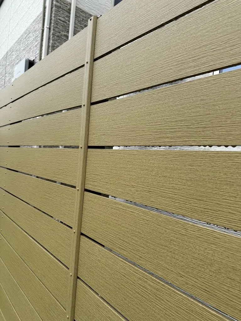 横板の程よい隙間で風や光を通し、圧迫感を抑えた木目調の樹脂目隠しフェンス