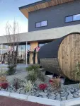 川砂利やゴロタ石を使った和モダンの雰囲気があるロックガーデン風の庭。植栽は手入れが比較的楽で、四季を楽しめる種類が選ばれている。真ん中には存在感のあるバレルサウナ